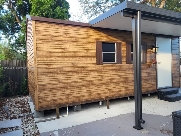 a view of a porch with a chair and table in front of house