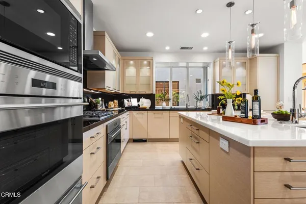 a large kitchen with kitchen island granite countertop a sink stainless steel appliances and cabinets