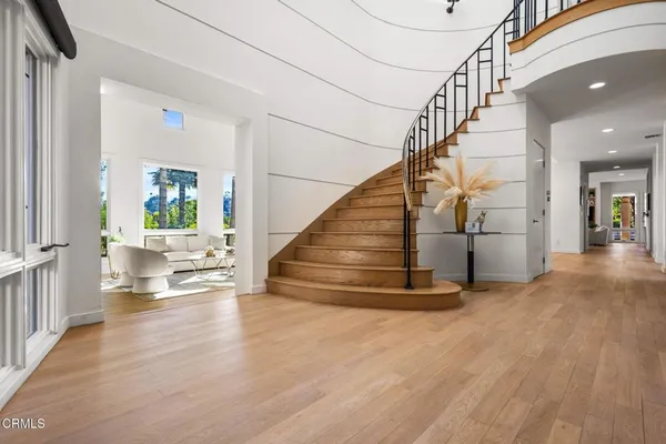 a view of entryway and hall with wooden floor