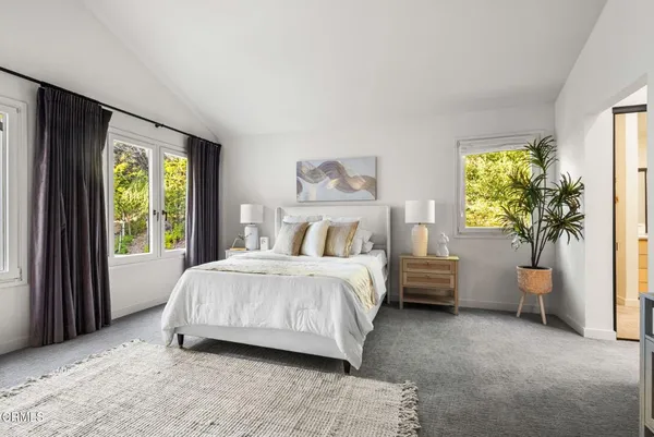 a bedroom with a bed couch and window