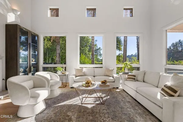 a view of a dining room and livingroom with furniture wooden floor a chandelier