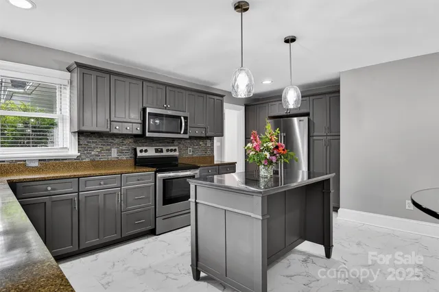 a kitchen with stainless steel appliances granite countertop a stove and a wooden cabinets
