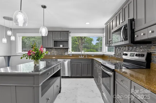 a kitchen with stainless steel appliances granite countertop a stove and a sink