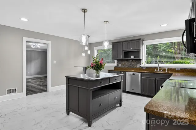 a kitchen with stainless steel appliances granite countertop a stove a sink and a refrigerator
