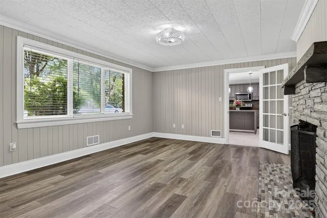 a view of empty room with wooden floor and fireplace