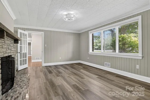 a view of empty room with wooden floor and fireplace