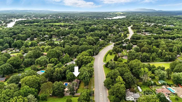 an aerial view of a residential houses with outdoor space and trees