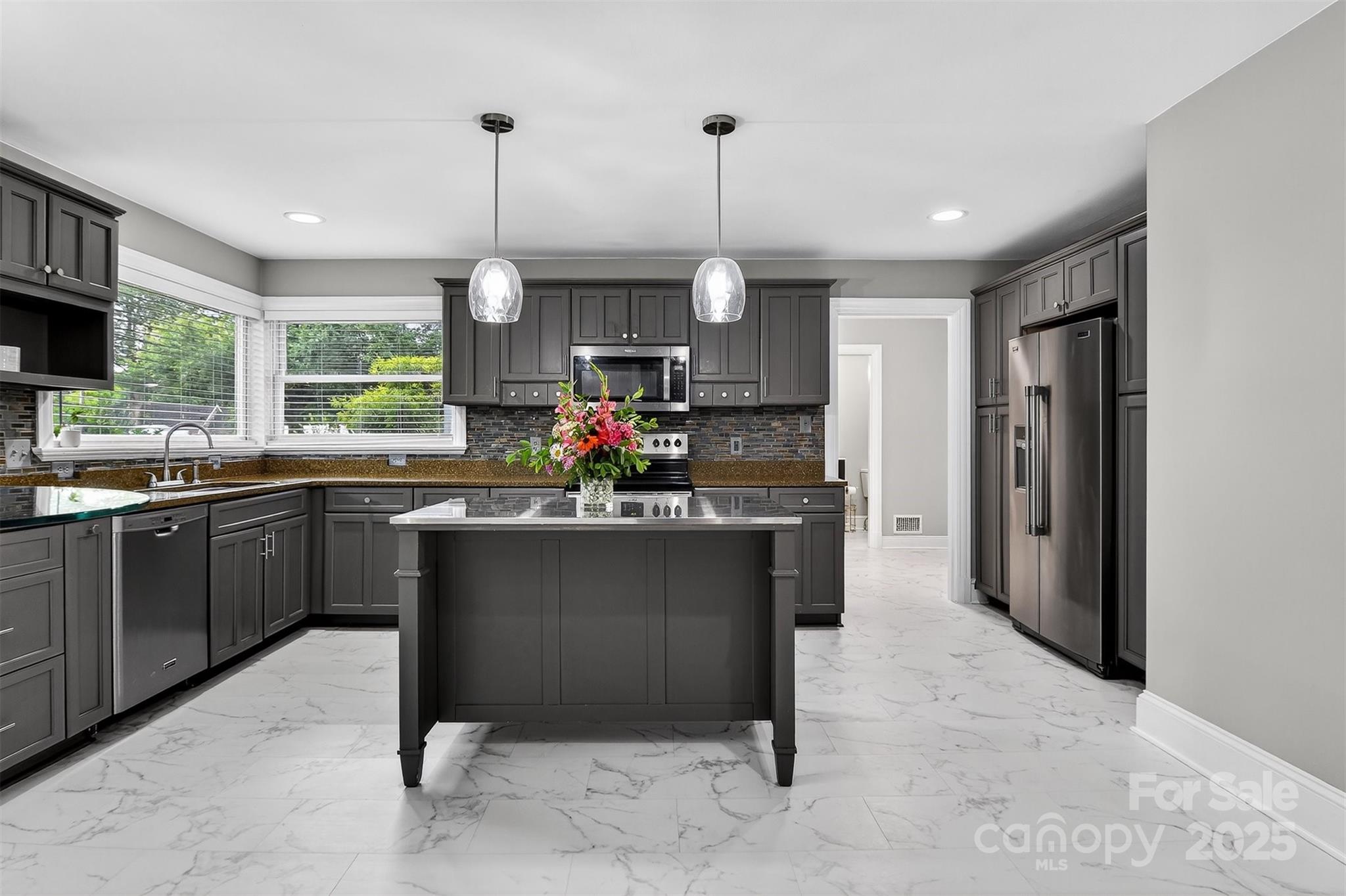 3127 North Center Street Hickory, NC 28601 - Photo 9 of 47 a kitchen with stainless steel appliances granite countertop a refrigerator a sink dishwasher a stove and a dining table with wooden floor