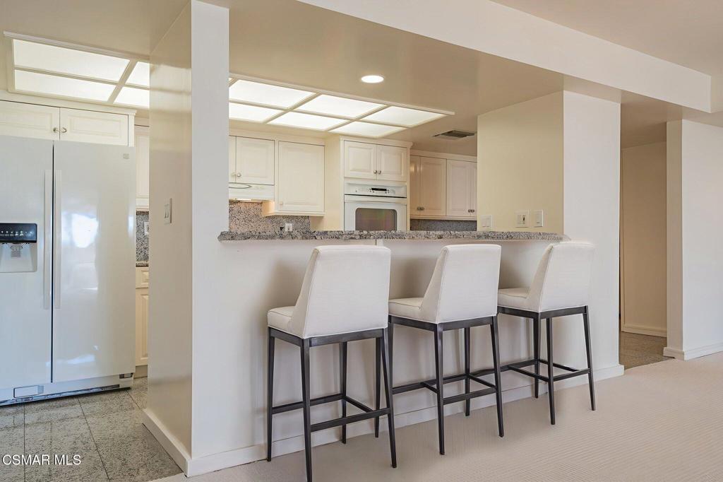 10660 Wilshire Boulevard, Unit 410 Los Angeles, CA 90024 - Photo 12 of 85 a dining area with granite countertop a table chairs refrigerator and microwave
