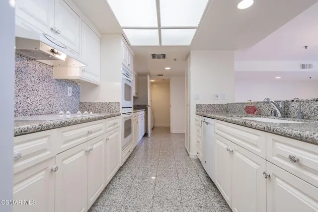 a bathroom with a granite countertop sink a toilet and a mirror