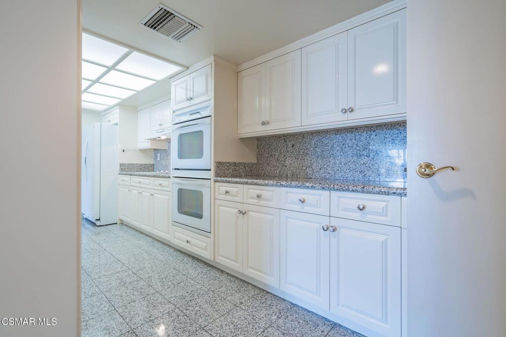 10660 Wilshire Boulevard, Unit 410 Los Angeles, CA 90024 - Photo 36 of 85 a kitchen with white cabinets and white appliances