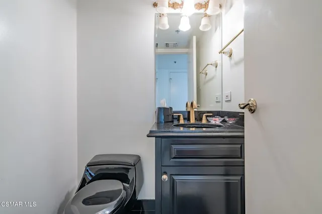 a bathroom with a granite countertop toilet a sink and shower