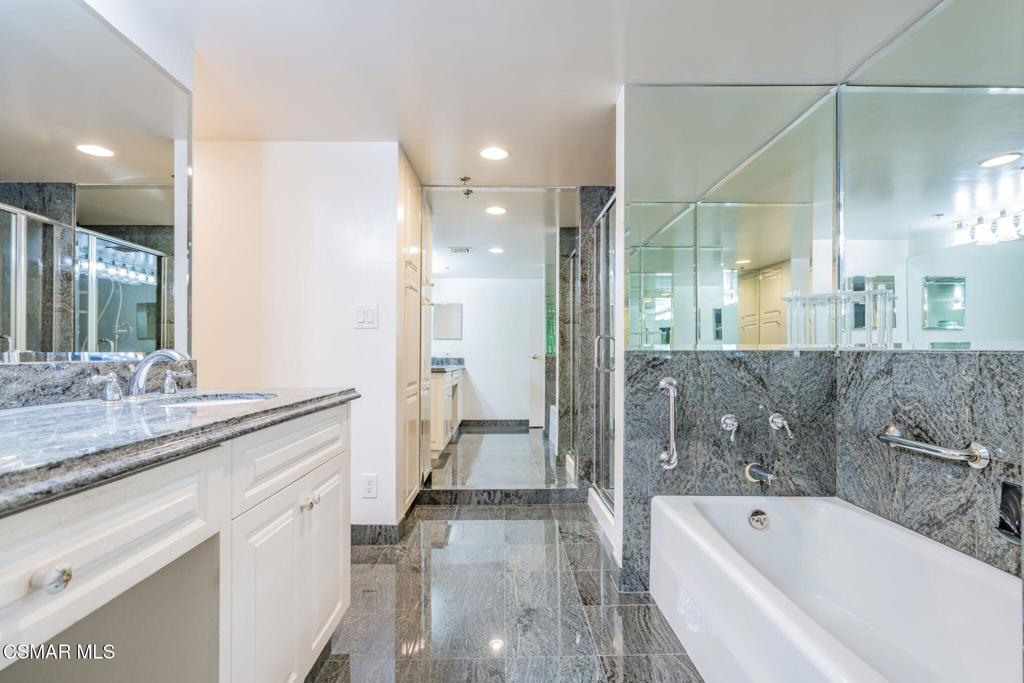 10660 Wilshire Boulevard, Unit 410 Los Angeles, CA 90024 - Photo 47 of 85 a bathroom with a granite countertop sink mirror and a bath tub