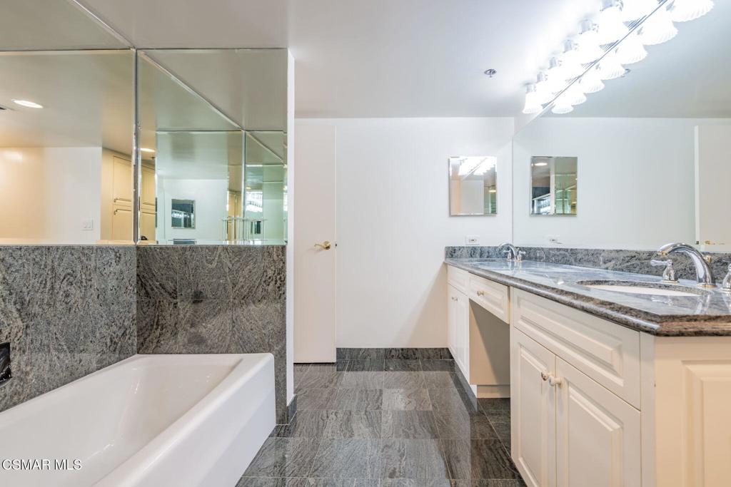 10660 Wilshire Boulevard, Unit 410 Los Angeles, CA 90024 - Photo 50 of 85 a bathroom with a granite countertop sink a bathtub and shower