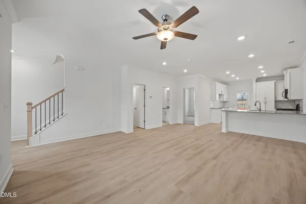 an empty room with windows and fan