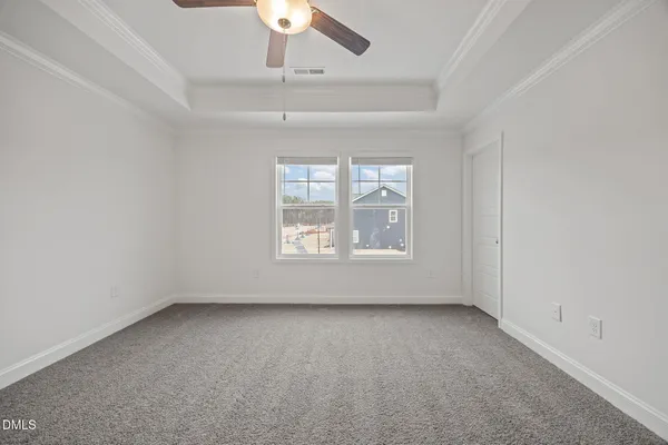 an empty room with windows and ceiling fan