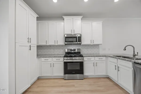 a kitchen with white cabinets and white appliances