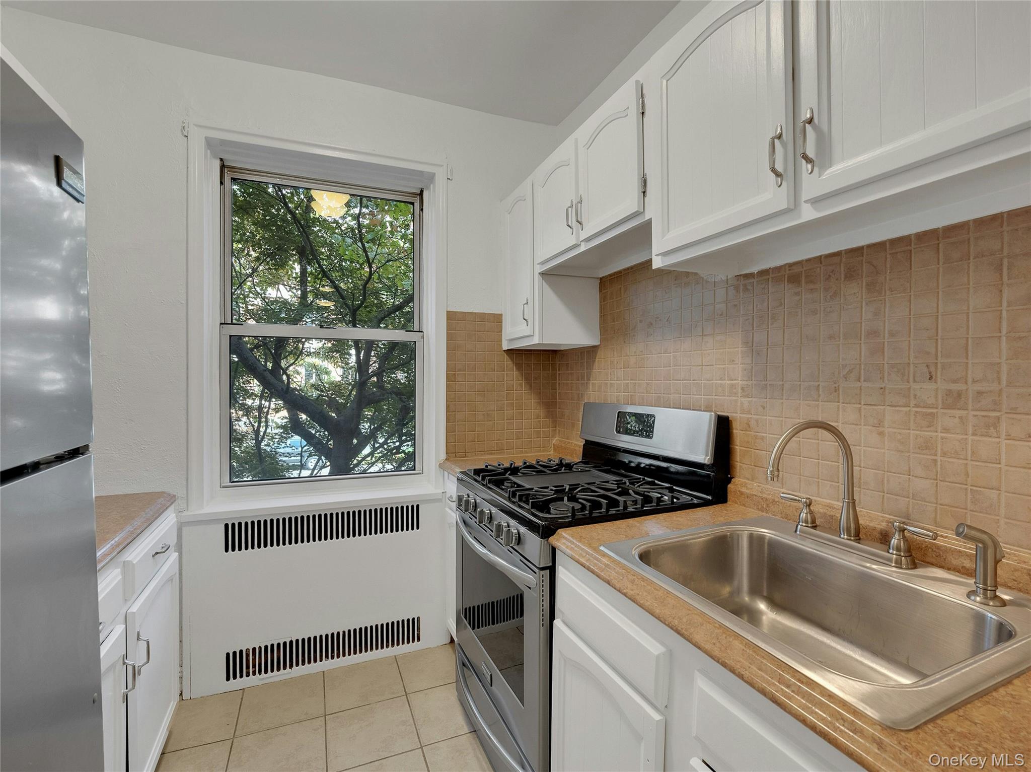 764 Palmer Road, Unit 1B Bronxville, NY 10708 - Photo 11 of 29 a kitchen with granite countertop a sink cabinets and window