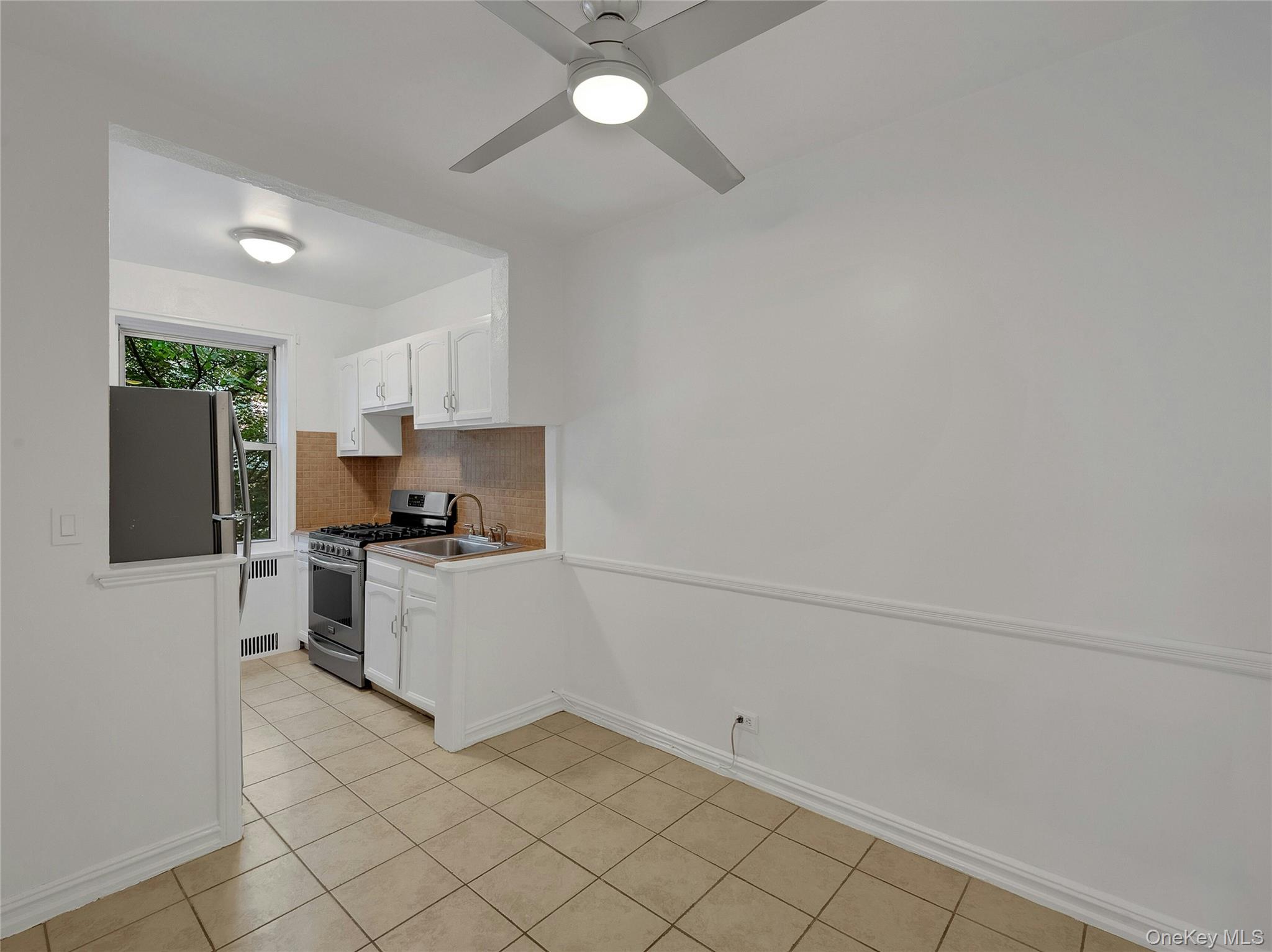 764 Palmer Road, Unit 1B Bronxville, NY 10708 - Photo 13 of 29 a kitchen with a refrigerator and white cabinets