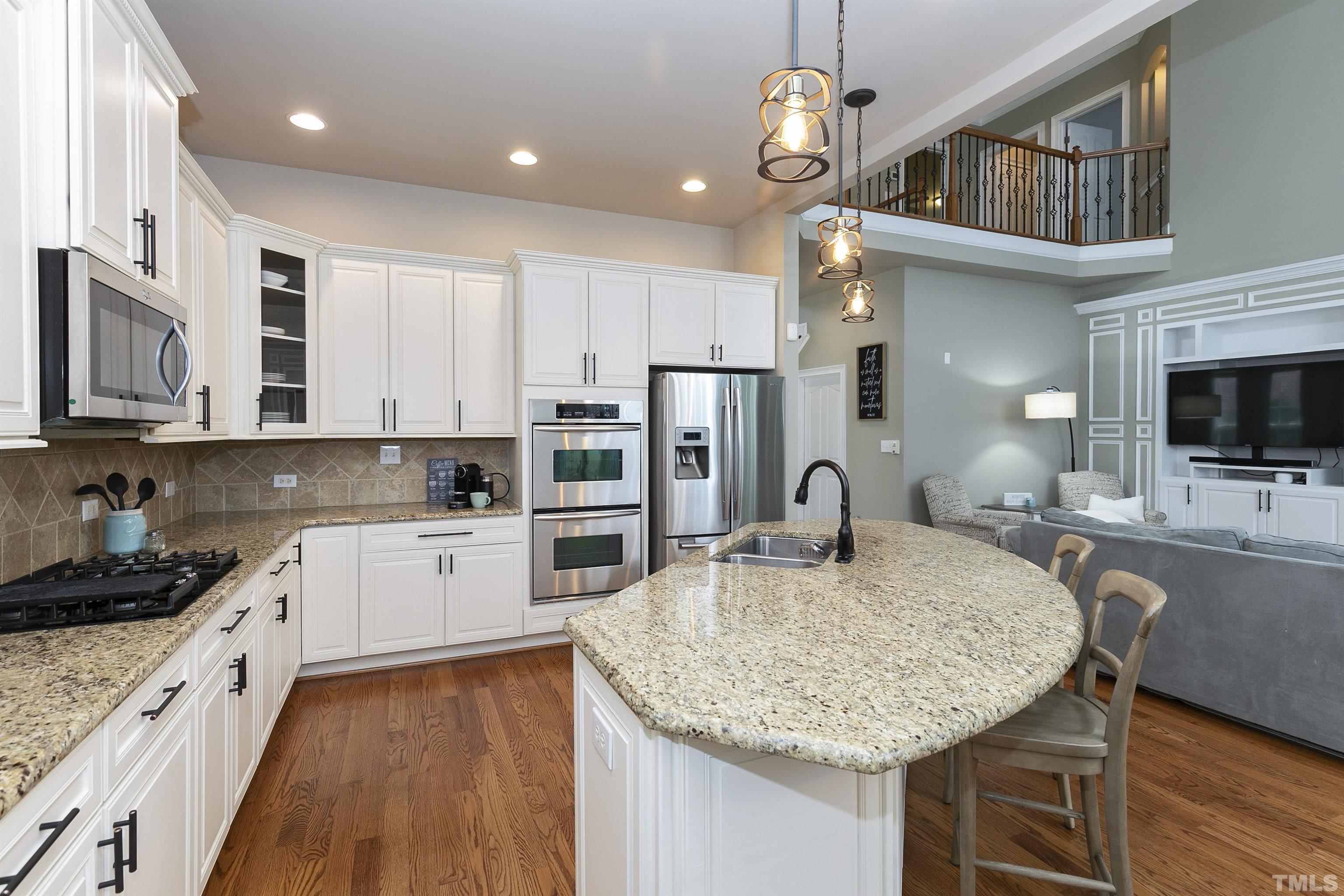 2255 Clayette Court Raleigh, NC 27612 - Photo 3 of 59 a kitchen with stainless steel appliances granite countertop a sink dishwasher and a stove with wooden floor