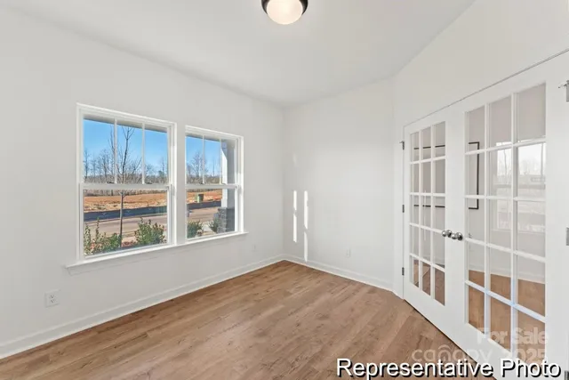 a view of a livingroom with wooden floor and windows