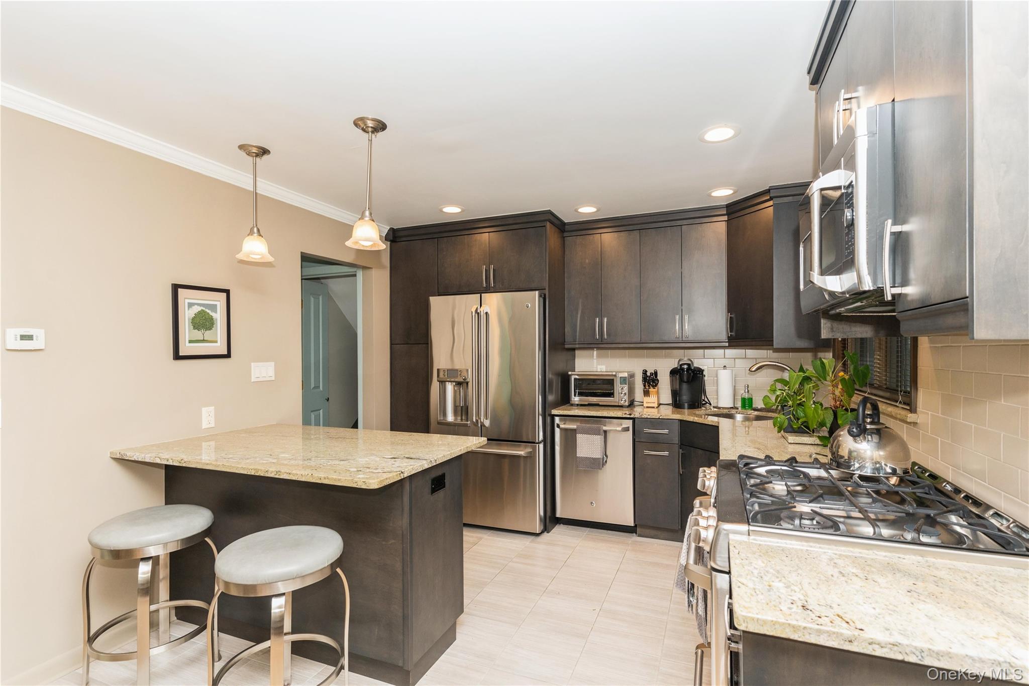 2772 Riverside Avenue Merrick, NY 11566 - Photo 4 of 45 a kitchen with granite countertop a stove a sink cabinets and stainless steel appliances