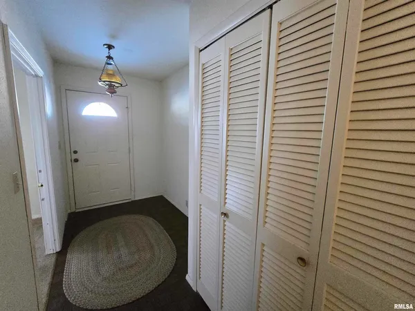 a view of a livingroom with wooden floor and a bathroom