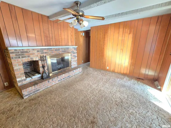 a view of an empty room with a fireplace and a window