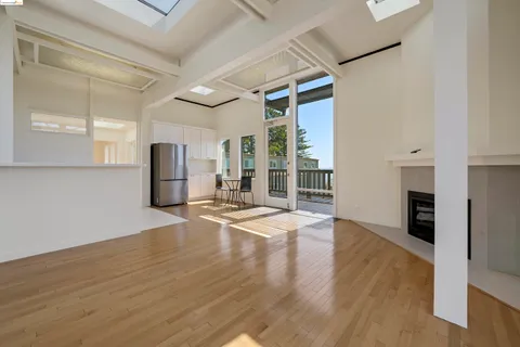 a view of empty room with wooden floor and fireplace