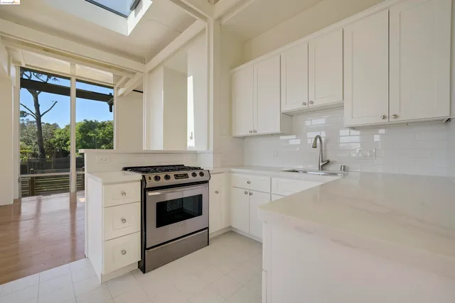 a kitchen with granite countertop white cabinets and white appliances