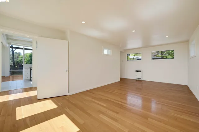 a view of an empty room with wooden floor
