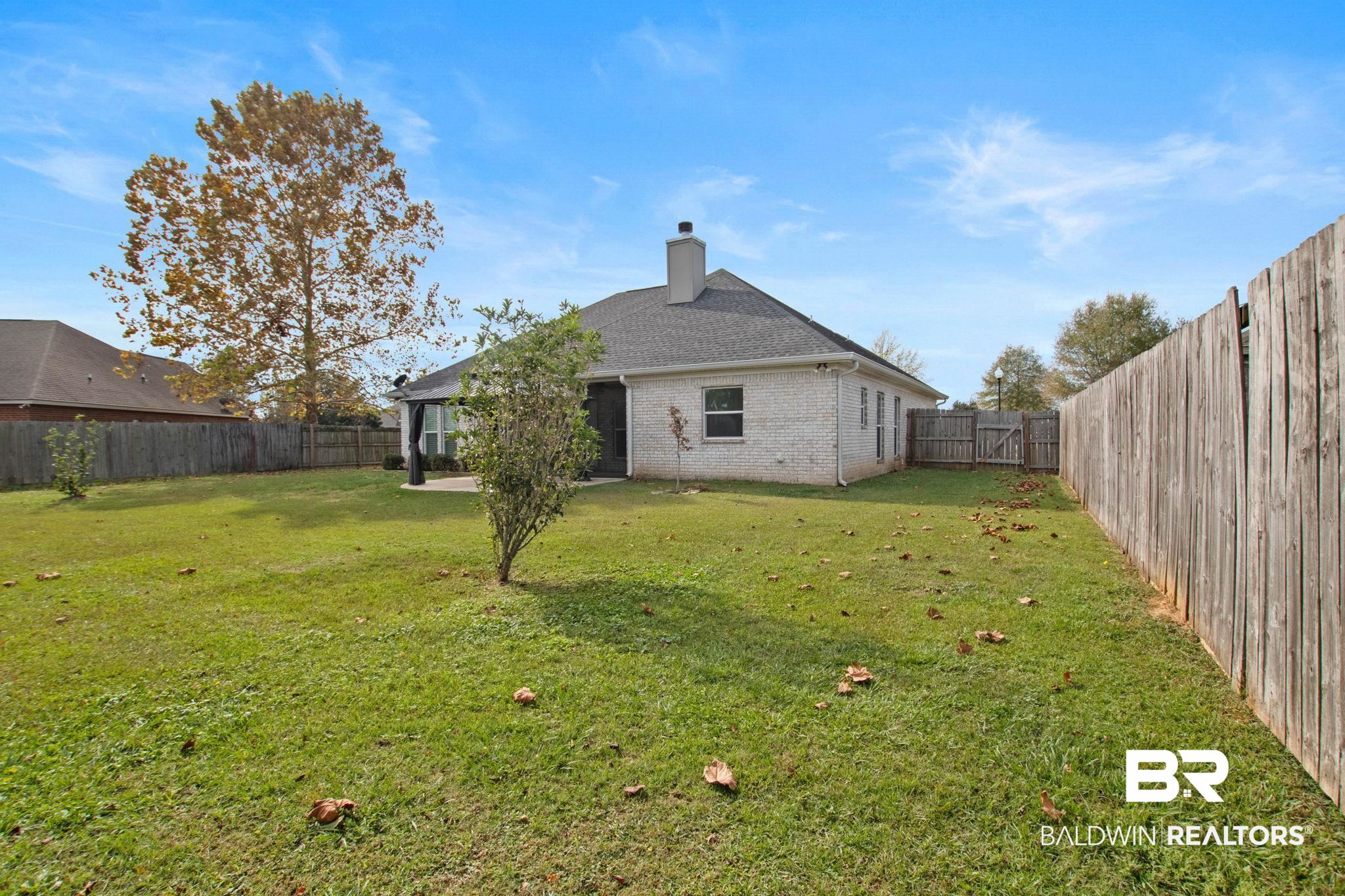 17376 Bankhead Boulevard Fairhope, AL 36532 - Photo 64 of 73 Rear view of property featuring a patio area, a fenced backyard, brick siding, a chimney, and roof with shingles