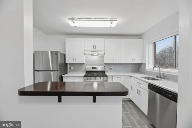a kitchen with a appliances cabinets and a sink