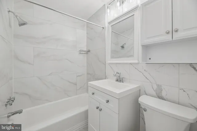 a bathroom with a sink a toilet and bathtub