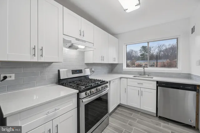 a kitchen with white cabinets and appliances
