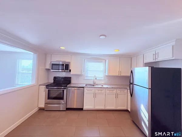 a kitchen with stainless steel appliances a refrigerator sink and stove