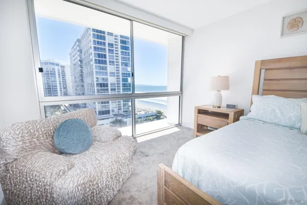 a bedroom with a bed and a large window