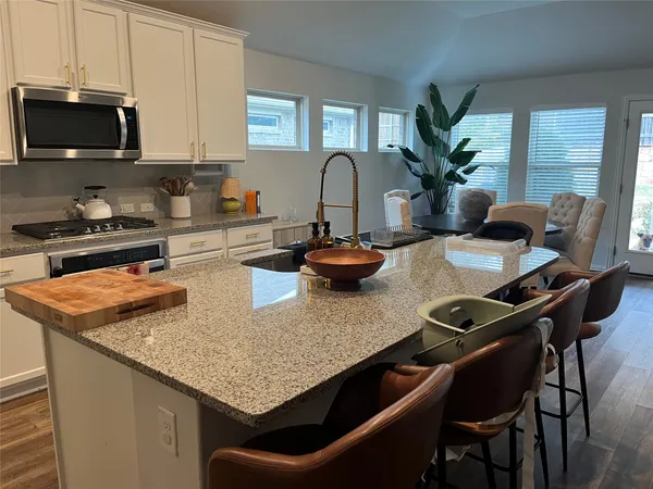 a kitchen with a stove a sink and a white cabinets