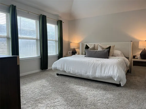 a bedroom with a bed lamp and a large window