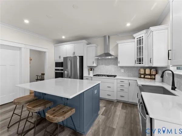 a kitchen with stainless steel appliances a stove a sink and a refrigerator