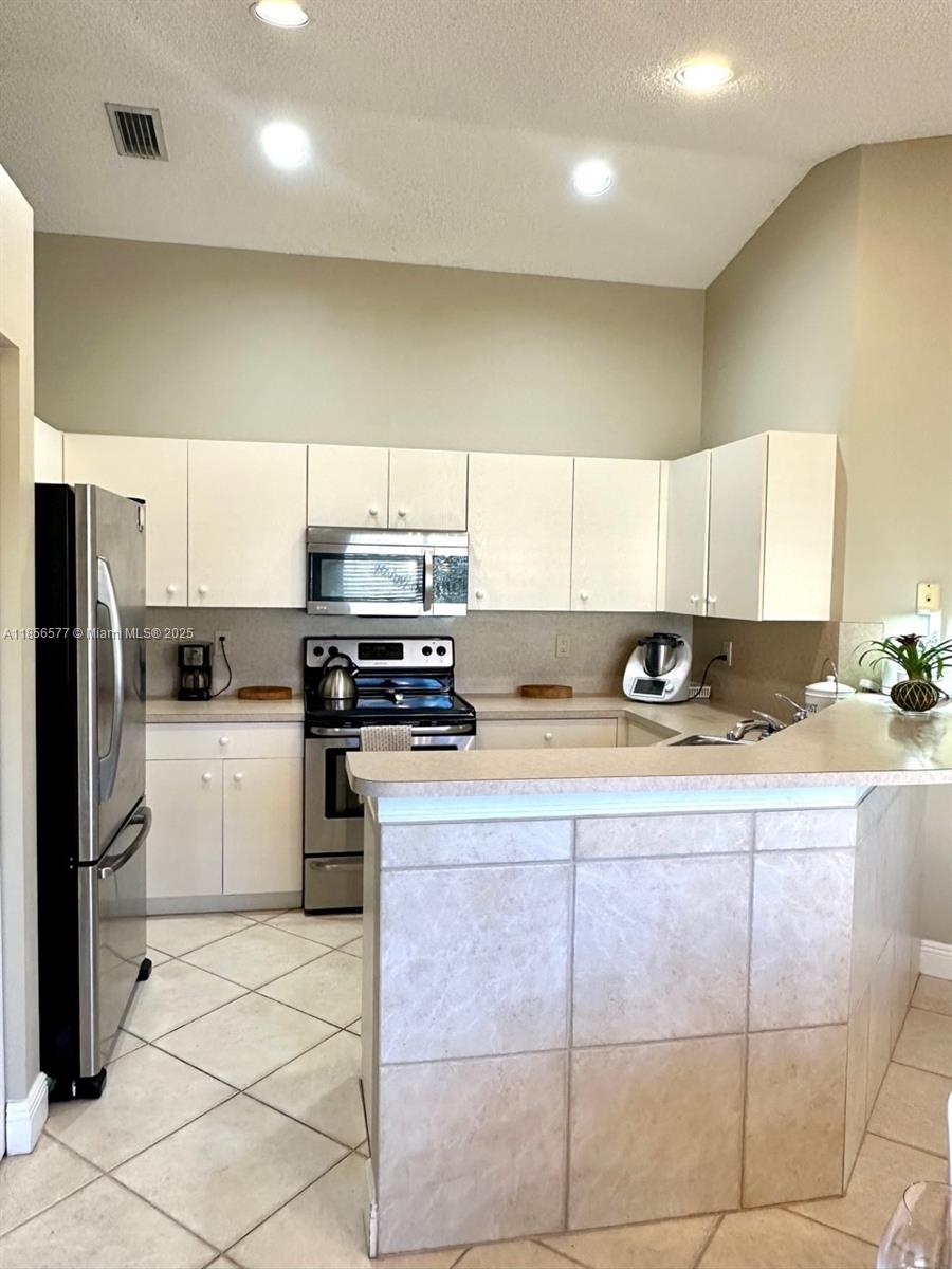 4370 Pine Ridge Court Weston, FL 33331 - Photo 11 of 39 a kitchen with a sink window and stainless steel appliances