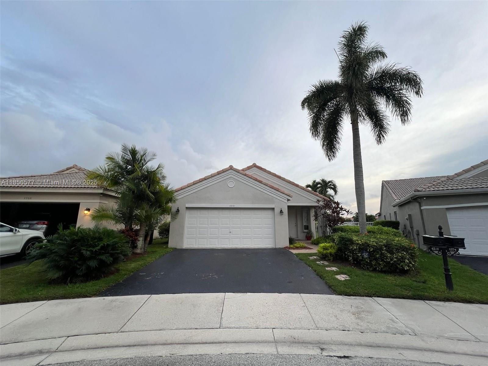 4370 Pine Ridge Court Weston, FL 33331 - Photo 2 of 39 a front view of a house with a yard and garage