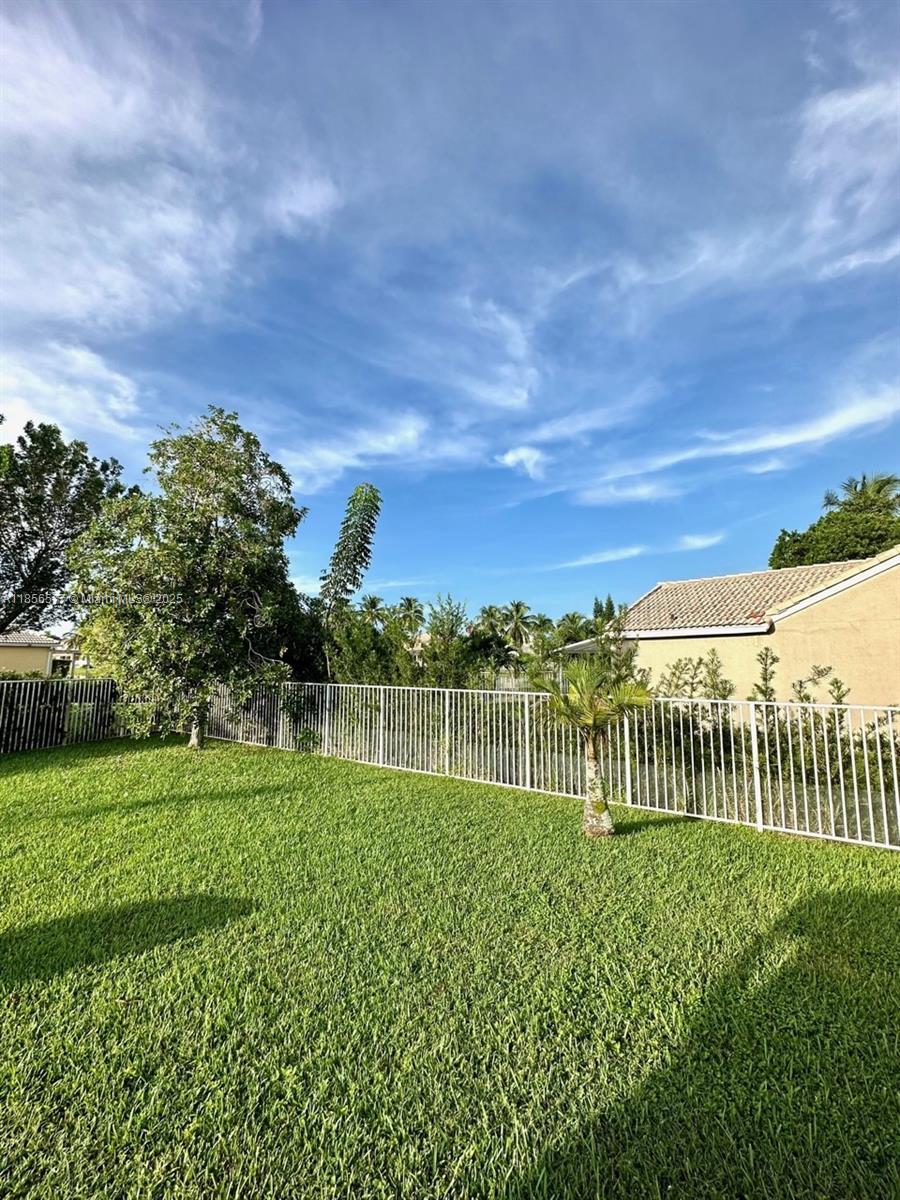 4370 Pine Ridge Court Weston, FL 33331 - Photo 36 of 39 a view of a green field with wooden fence