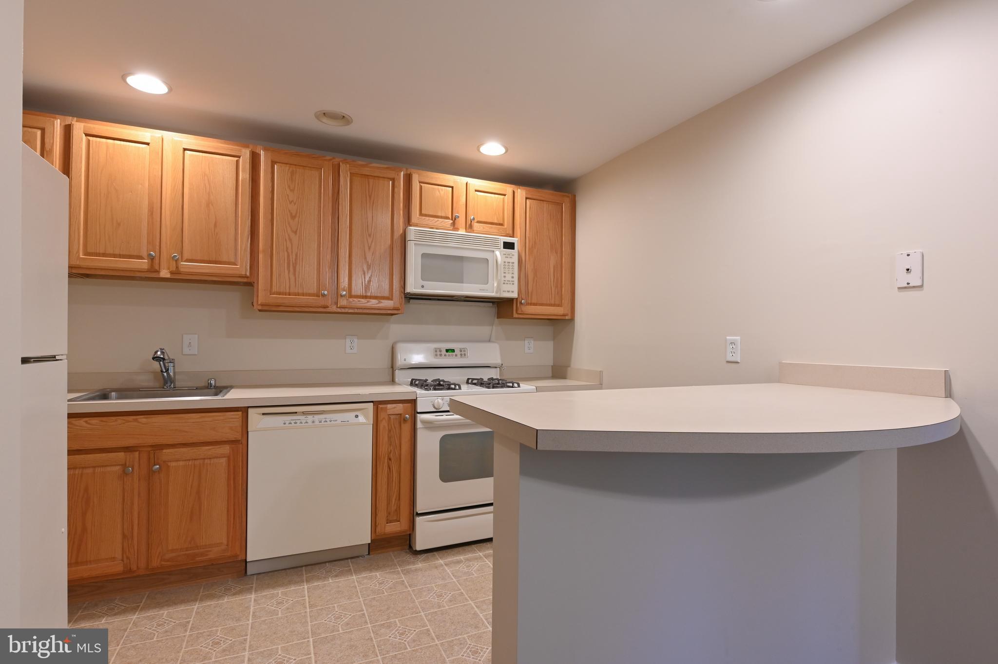 206 F Victor Parkway, Unit 206F Annapolis, MD 21403 - Photo 7 of 21 a kitchen with stainless steel appliances granite countertop a sink and dishwasher a stove top oven with white cabinets