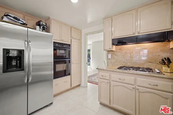 a kitchen with stainless steel appliances granite countertop a refrigerator and a stove