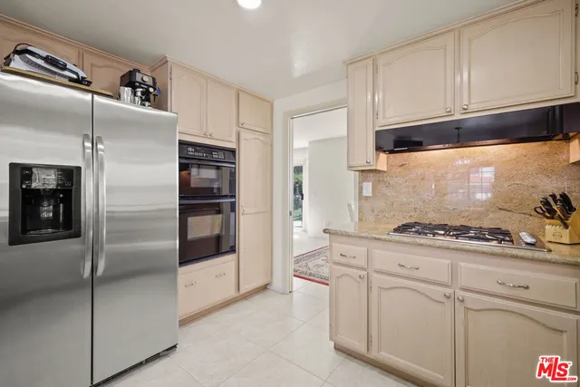 a kitchen with stainless steel appliances granite countertop a refrigerator and a sink