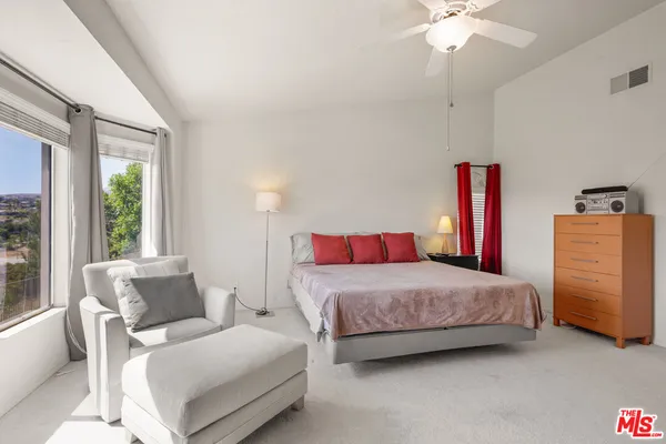 a bedroom with a bed and a ceiling fan