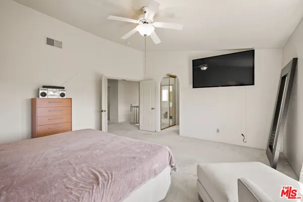 a spacious bedroom with a large bed and a chandelier