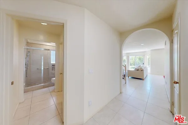 a view of a hallway view with three rooms and a livingroom with furniture