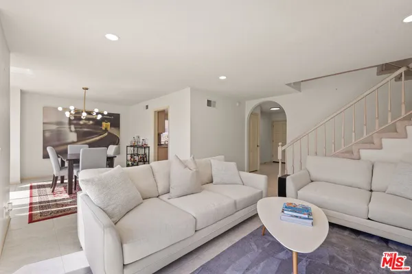 a living room with furniture kitchen view and a table